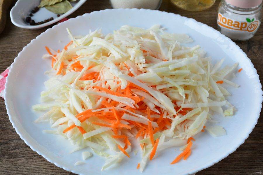 Натрите морковку на терке и перемешайте с капустой, хорошо разомните.