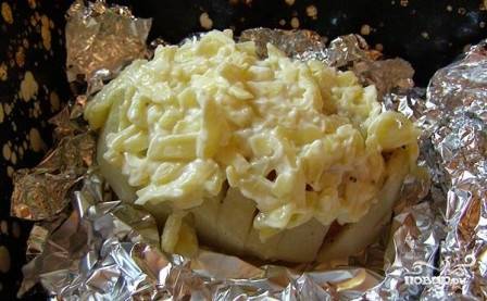 Достаем картофель из духовки, разворачиваем фольгу и затем на каждую картофелину накладываем сырно-майонезную массу.