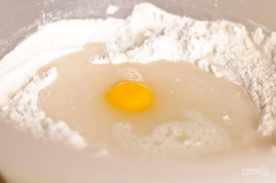 Муку просейте в глубокую миску, добавьте соль, яйцо и теплую воду.