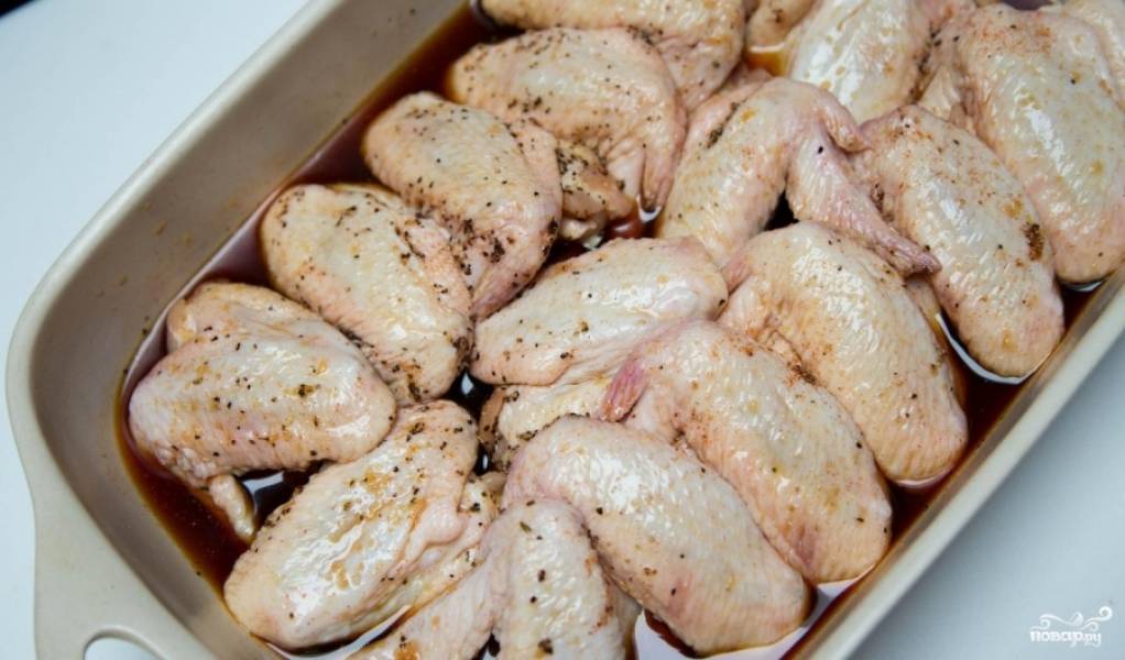 Выложите в форму для выпекания мытые подготовленные куриные крылышки. И залейте их нашей пряной глазурью.