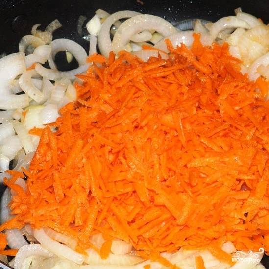 Добавляем к луку крупно натертую морковь, перемешиваем и готовим еще 5 минут.