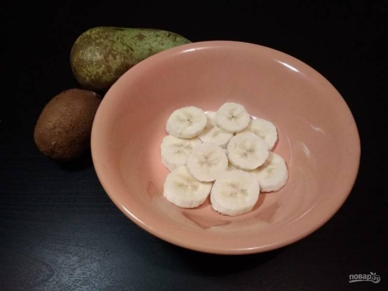 2. Бананы нарежьте кружками. Затем разложите их первым слоем в глубокие тарелки(у) для подачи.