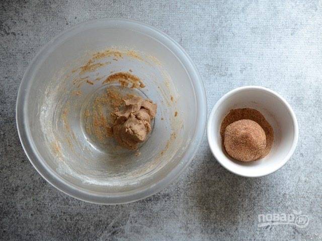 5. Смешайте оставшуюся корицу и сахар. Разделите тесто на 2 части, сформируйте из каждой шарик и обваляйте его в сахарной смеси.