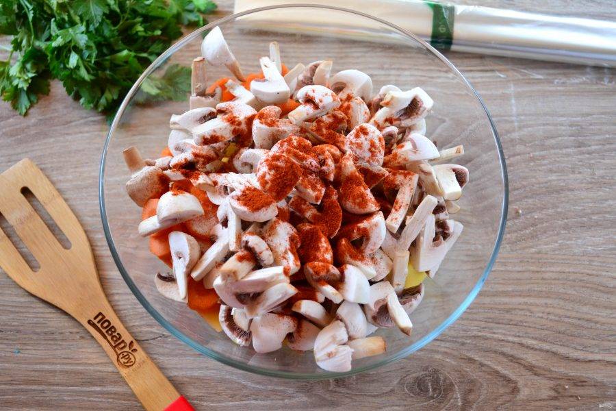 Переложите все овощи и грибы в большую миску, посолите, добавьте перец, паприку, растительное масло. Хорошо перемешайте.
