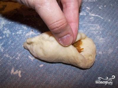 От теста отделяем куски размером с грецкий орех и формируем лепешку, на середину которой кладем примерно 2 ч.л. начинки. Защипываем. 