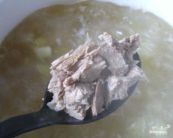 Мясо, когда оно немного остынет, освободите от костей и разберите на волокна. Положите его в бульон и доведите суп до кипения. 