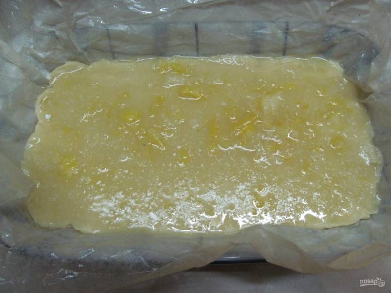 Вместе с пергаментом перенесите тесто в форму для запекания и распределите лимонную начинку. 