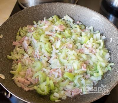 Для соуса мелко нарежьте бекон, сельдерей и лук. Обжарьте эти ингредиенты в масле в течение 4-х минут, помешивая.