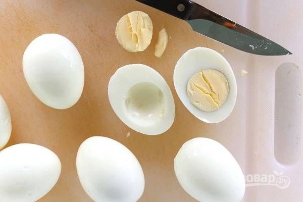 2. Яйца очистите, нарежьте половинками и аккуратно достаньте желтки. 