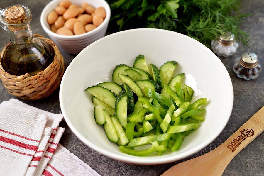 Почистите перец от семечек и плодоножки, обрежьте кончики с обеих сторон на огурцах, нарежьте овощи тонкой соломкой. 