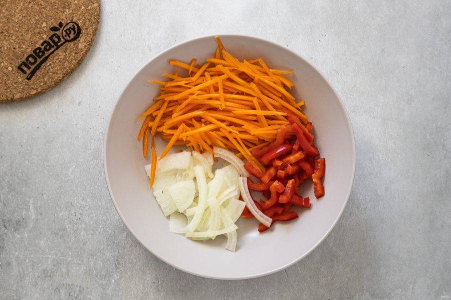 Морковь натрите на терке для моркови по-корейски, а лук тонкими полукольцами. Сладкий перец нарежьте тонкой соломкой.