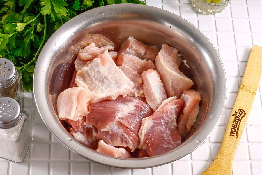 Нарежьте мясо на порционные кусочки и выложите в глубокую емкость. Размер кусочков определяйте по своему вкусу.