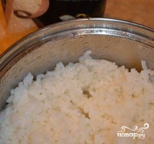 В небольшой кастрюльке доведите до кипения слегка подсоленную водичку. Затем насыпьте в нее рис и варите до полной готовности столько, сколько это написано производителем на упаковке. Затем в готовый рис влейте рисовый уксус и тщательно все перемешайте. Дайте рису остыть. 