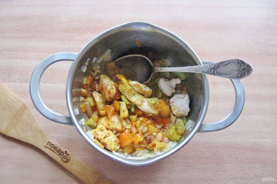 Добавьте в кастрюлю с овощами и курицей специи и перемешайте.