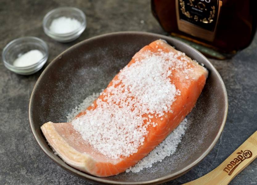 Переложите кусок лосося в глубокую миску кожей вниз, посыпьте рыбу солью и сахаром.  