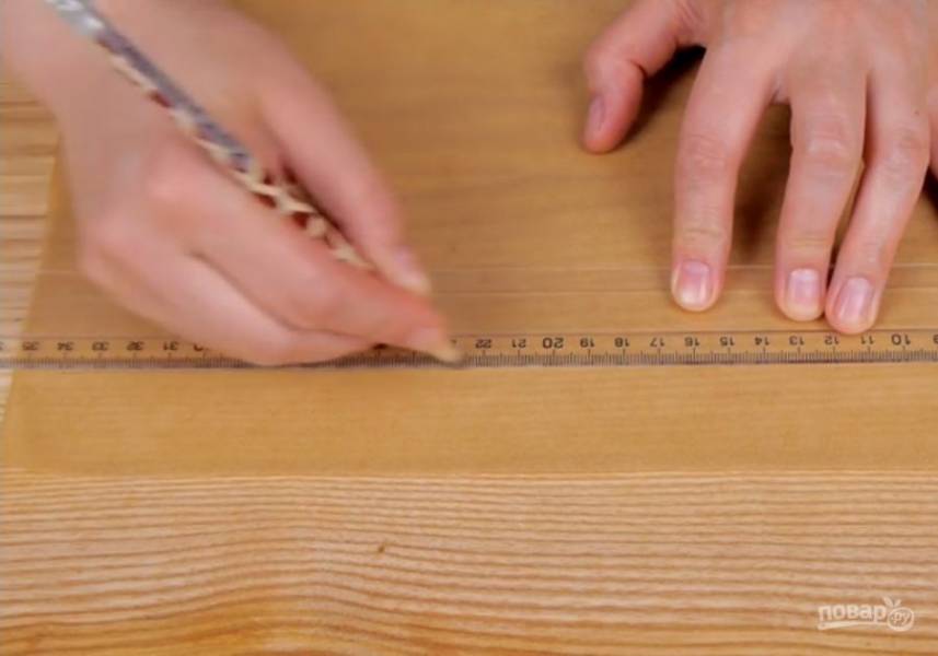1. Измерьте окружность и высоту формы. Сделайте две разметки на бумаге для выпечки: длиной в половину окружности формы, а высотой равной высоте формы + 1 см. Дно формы застелите бумагой для выпечки. 