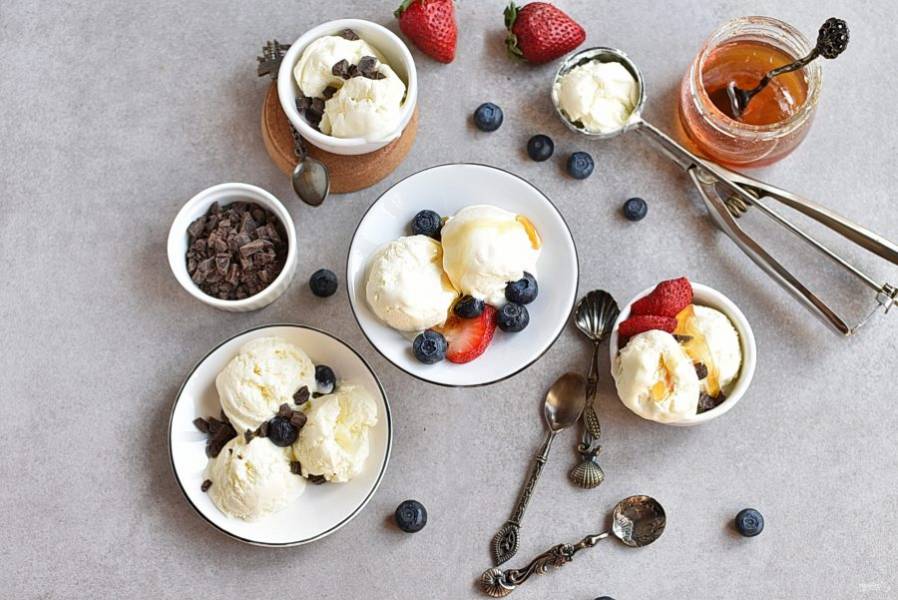 Замерзшее мороженое разложите по порциям с помощью специальной ложки и подавайте с фруктами, топпингами и шоколадом.