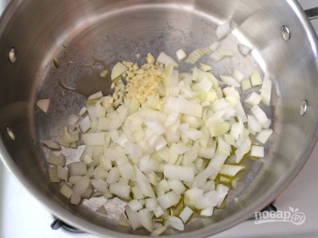 1.	Почистите чеснок и лук. Нарежьте кубиками лук, а чеснок измельчите. Положите лук и чеснок в кастрюлю с разогретым оливковым маслом и готовьте на среднем огне пока лук не станет мягким.