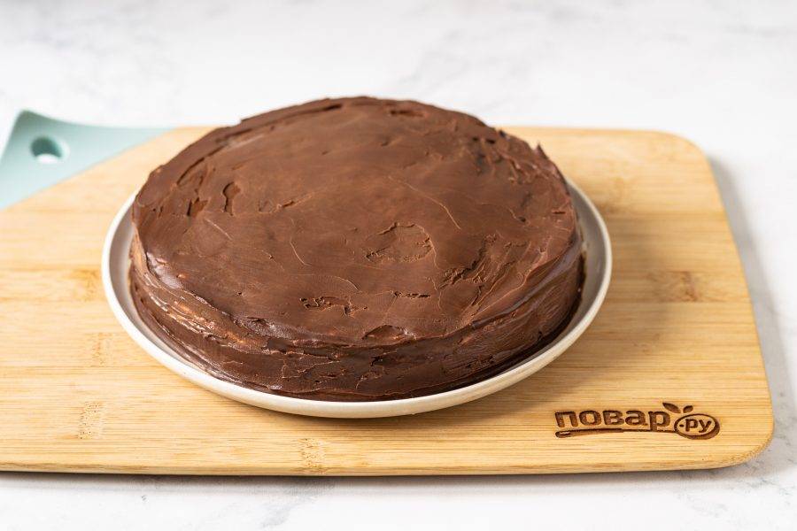 Смажьте верхушку и бока торта шоколадным кремом. Уберите в холодильник на 15-20 минут.