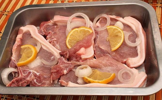 


Мясо порезать на порции, отбить и уложить в форму. Сверху выложить кружочки лимона и лук.