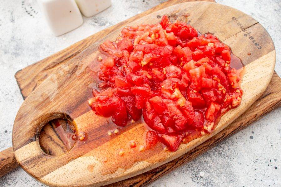 Нарежьте мелким кубиком, если не очищать от семян, то откиньте нарезанные помидоры на сито и слегка придавите ложкой, чтобы стек лишний сок.
