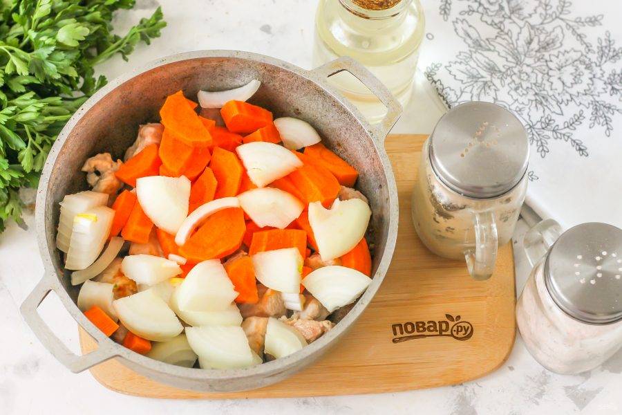 Добавьте нарезки лука и моркови к поджаренному мясу, томите еще 2-3 минуты, пока и овощи не подрумянятся.