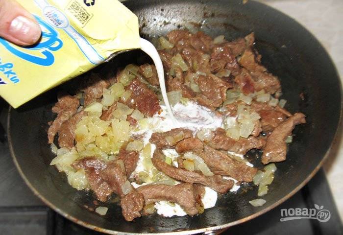 Спустя час верните на сковороду к говядине лук, влейте сливки и дайте им закипеть. 