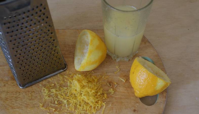 Лимоны промываем, разрезаем пополам и выжимаем с них сок. Цедру снимаем теркой.