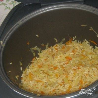Затем добавьте к овощам хорошо промытый рис, оставшуюся воду, специи и соль. Тушите в течение 25 минут (до готовности риса) на режиме "Плов".