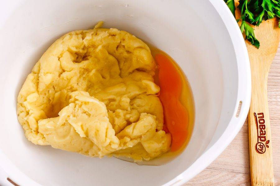 Выложите тесто в чашу кухонного комбайна или миксера, вбейте туда же куриное яйцо и вмешайте его в тесто на высокой скорости.