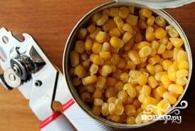 Открыть кукурузу, слить сок и высыпать зерна в миску с капустой.