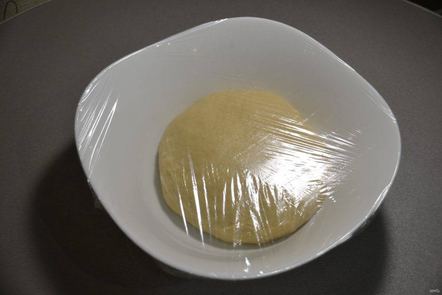 Уложите тесто в миску, края которой смазаны растительным маслом, накройте сверху пленкой. В таком виде дайте тесту подойти при комнатной температуре в течение 1-1,5 часов.