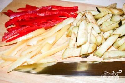 Перцы и баклажаны хорошо помойте, удалите из перцев сердцевину. Эти овощи нарежьте соломкой.