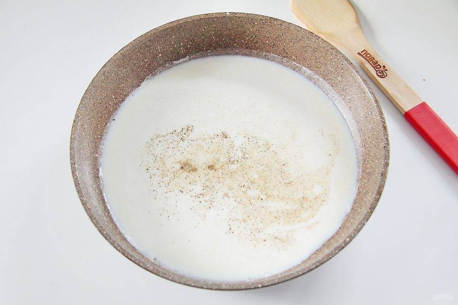 4. Тоненькой струйкой влейте молоко, постоянно размешивая образовавшиеся комочки. Добавьте соль и перец по вкусу.
