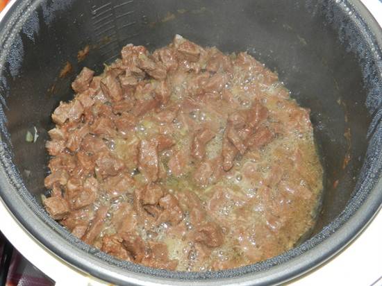 Включаем на мультиварке режим "Выпечка" на 40 минут. Мясо нарезаем на небольшие кусочки, а лук режем полукольцами, выкладываем их в чашу и обжариваем.