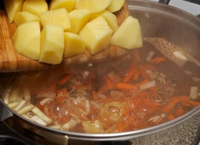 В кипящую воду бросьте корни сельдерея и петрушки, проварите 10 минут, затем добавьте морковь, а через 10 минут картофель. 