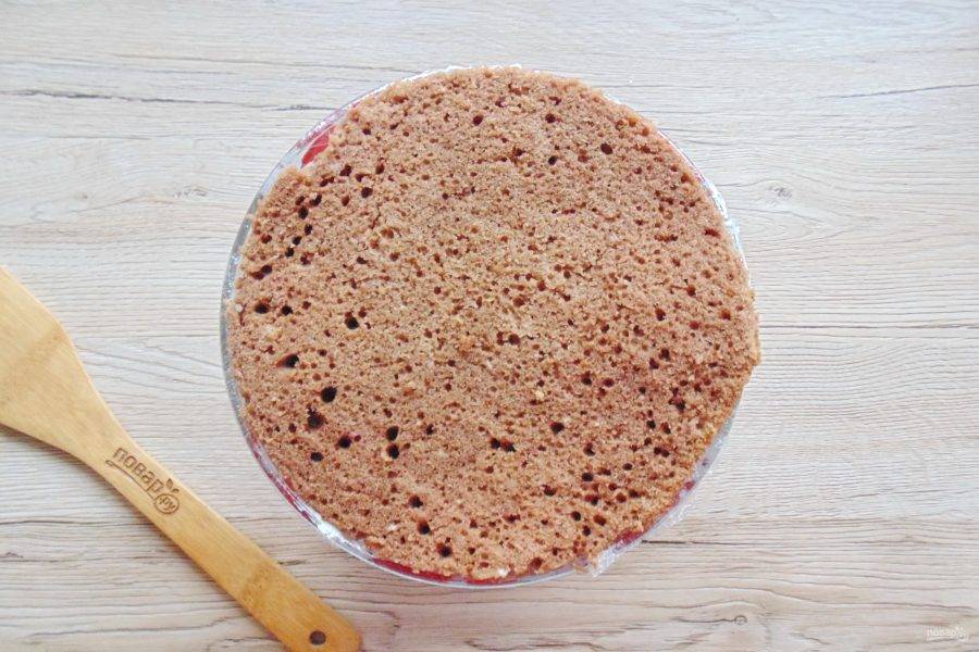 Верх миски с тортом накройте круглым коржом. 