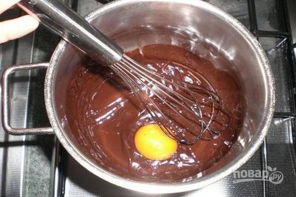 1.	Растопите шоколад со сливочным маслом на водяной бане, снимите с огня и добавьте желток. Перемешайте венчиком и добавьте сахар. Дайте массе остыть до комнатной температуры.