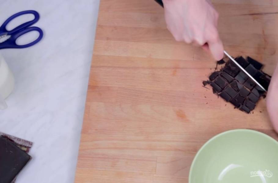 1. Измельчите шоколад с помощью ножа на мелкие кусочки и переложите его в сухую миску. Поставьте ее на водяную баню на небольшой огонь и периодически перемешивайте, чтобы шоколад расплавился. 