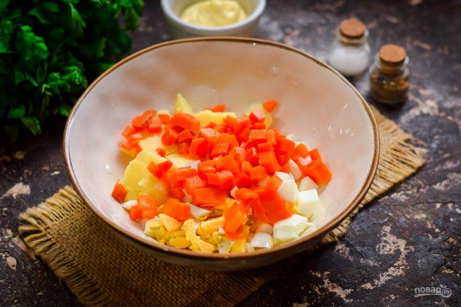 Следом нарежьте вареную морковь кубиками и переложите в салат.