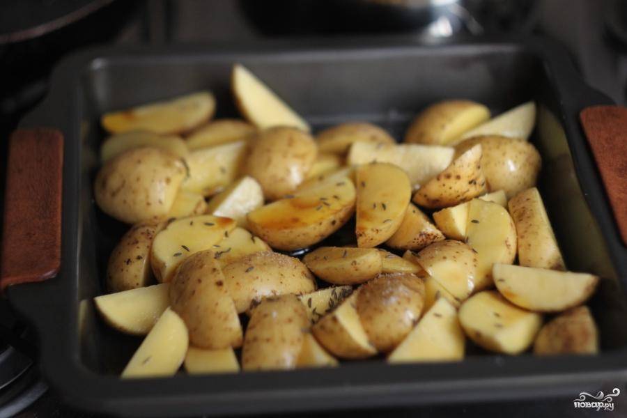 Нарезанный картофель уложить в смазанную маслом форму для выпекания. Картошку посолить, присыпать тмином, добавить соевого соуса и отправить выпекаться в разогретую духовку.