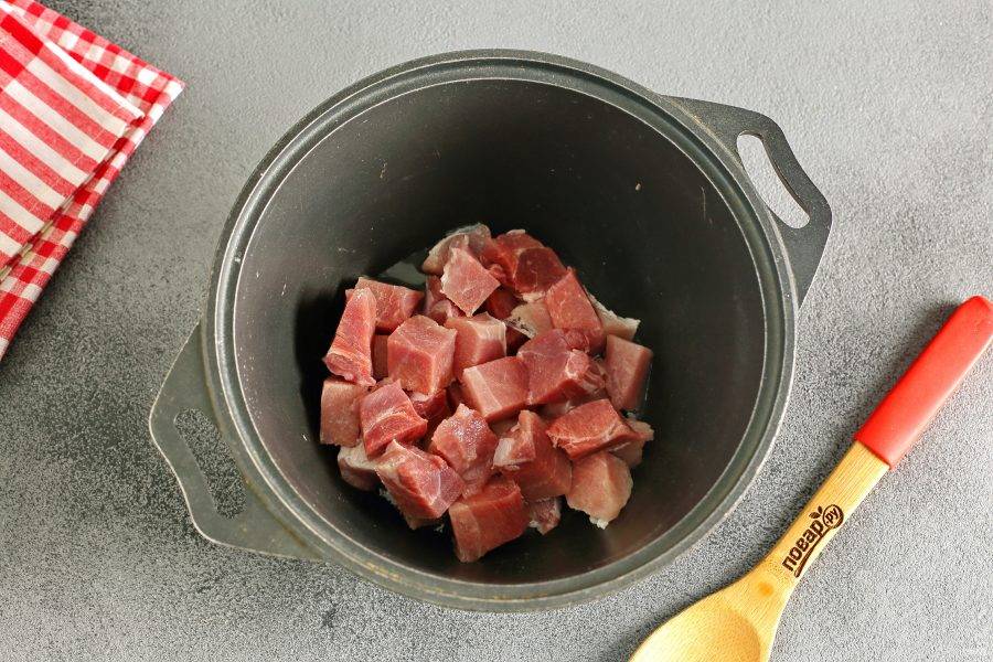 В казане или в любой посуде с толстым дном разогрейте масло. Выложите нарезанное кусочками мясо и обжарьте до появления легкой румяной корочки.