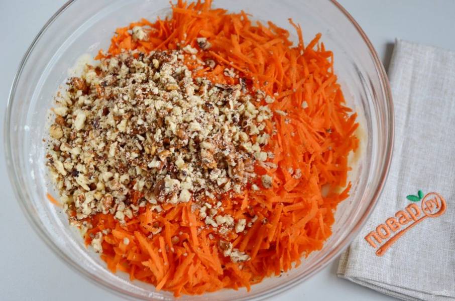Уберите венчик, в тесто положите морковь и орехи. Ложкой перемешивайте до соединения всех компонентов.
