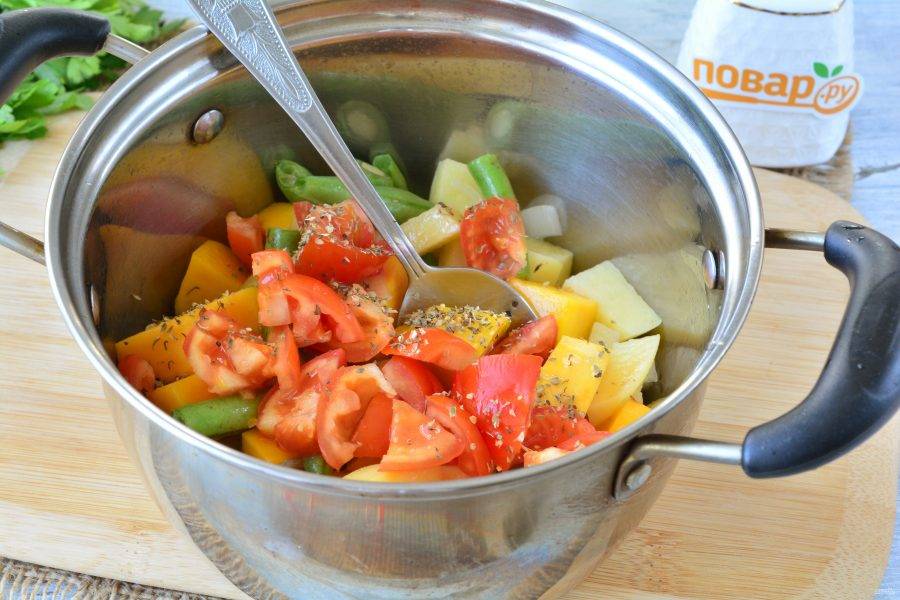 Добавьте в кастрюлю нарезанные дольками помидоры, добавьте специи и перемешайте.