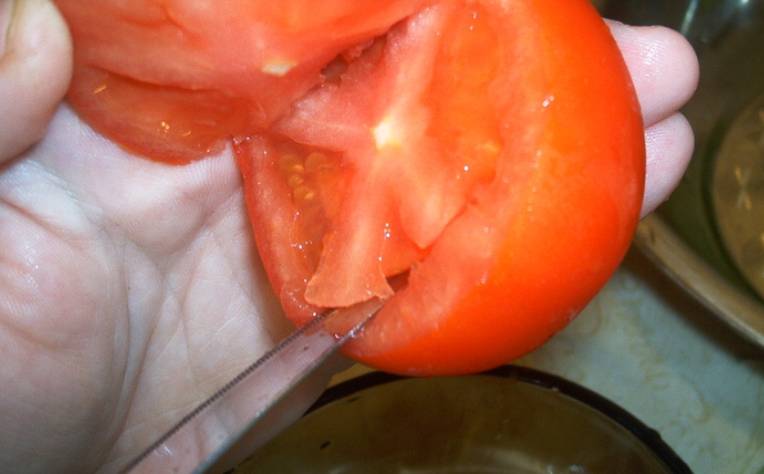 У перцев срезаем шляпки и удаляем семена (шляпки сохраняем). С томатами поступаем так же, аккуратно вырезая мякоть, но не полностью.