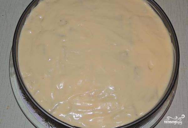 В форму для торта выкладываем кусочки бисквита, которые перед этим быстрыми движениями окунули в кофе. Наливаем половину крема. Выкладываем второй слой кусочков и крема.