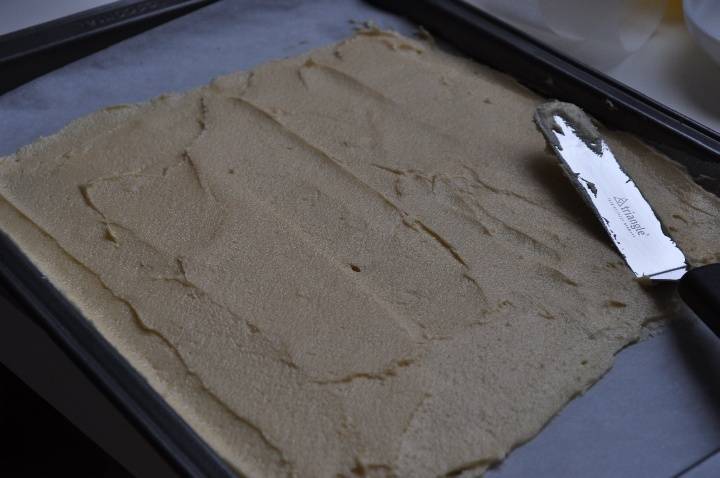 На противень выстилаем пергамент и на него наносим тесто тонким слоем. Затем отправляем корж выпекать в разогретую до 200 градусов духовку на 10-15 минут