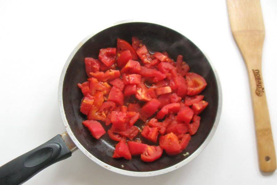 Нарежьте помидоры кубиками и выложите в сковороду. Обжарьте в масле.