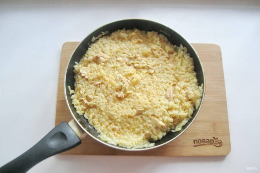 Накройте сковороду крышкой и готовьте рис с курицей 25-30 минут на небольшом огне.