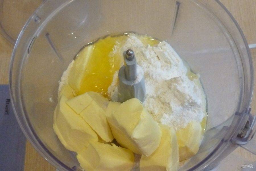 Для приготовления теста сложите все ингредиенты в кухонный комбайн: муку, нарезанное кубиками масло, яйцо, белый сахар, щепотку соли. Прокрутите и замесите тесто. При необходимости можно добавить немного холодной воды, чтобы тесто не рассыпалось.